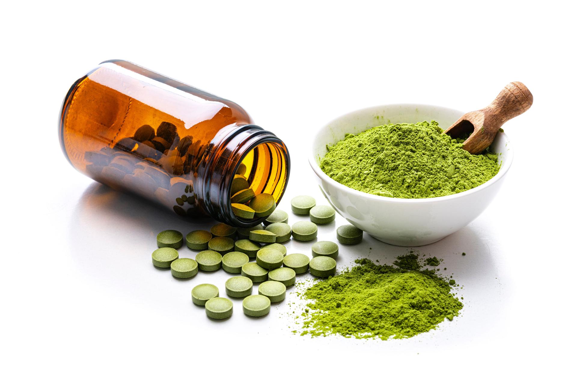 Moringa powder and pills on white background